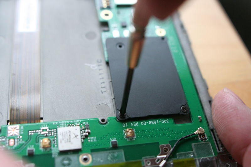 Nyní odšroubujte čtyři šroubky držící plastovou záslepku, na jejímž místě měl být GSM modul.