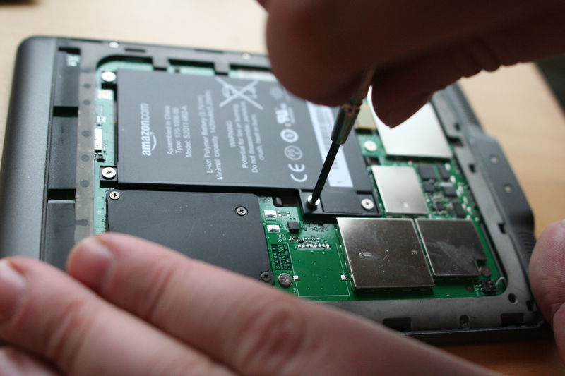 Nejprve musíme povolit pět šroubků, které drží baterii.