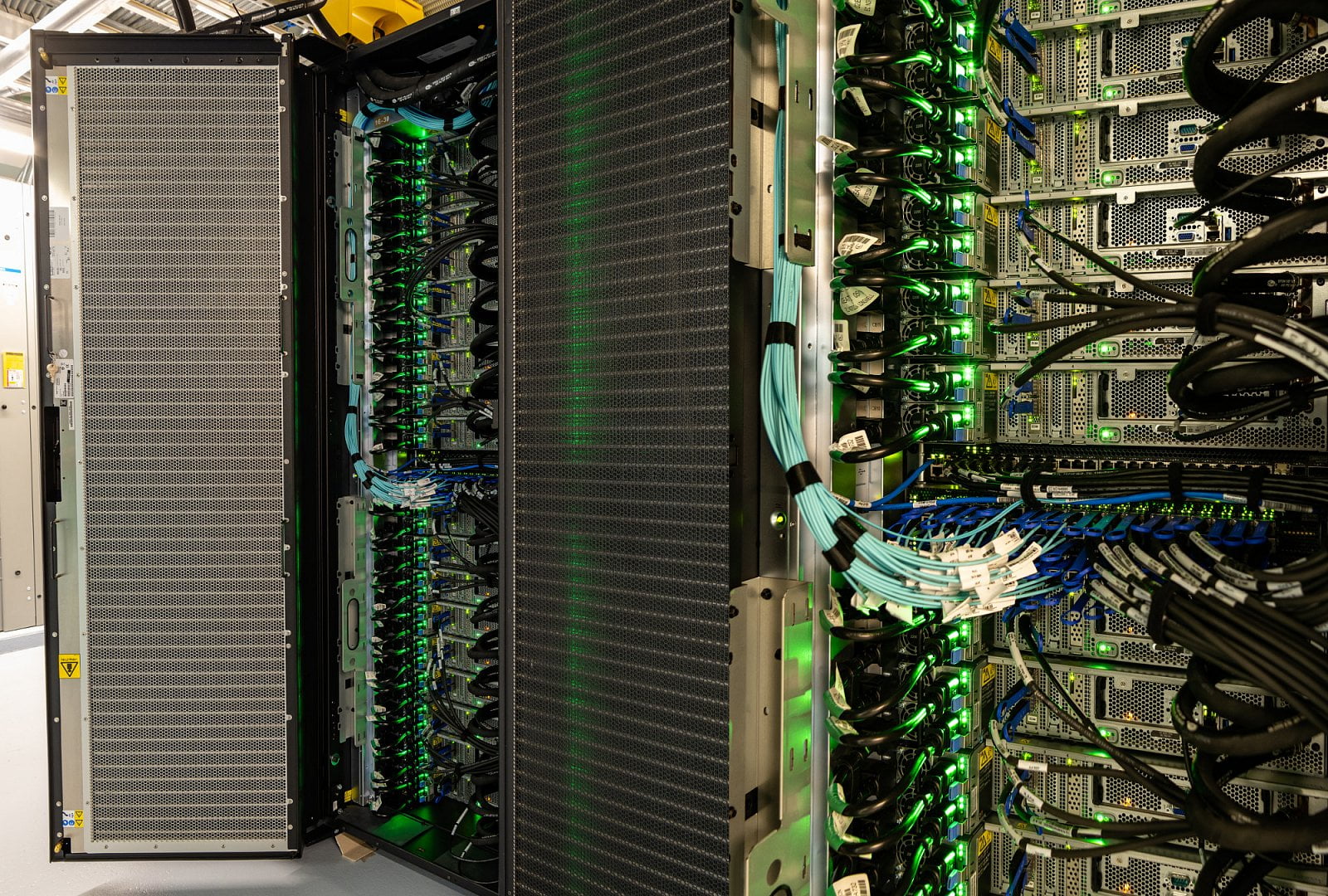 Pohled na zapojení v jednotlivých stojanech. Elektřina, data a chladicí voda. Jednotlivé uzly superpočítače jsou propojeny dvěma linkami Mellanox EDR InfiniBand s kapacitou 100 Gb/s.