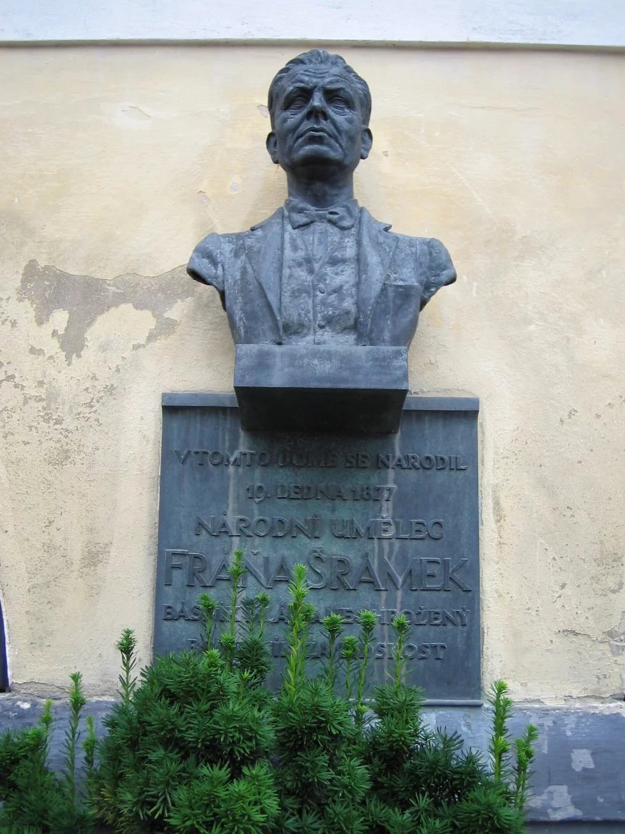 Bronzová pamětní deska s bystou básníka na zdi domu