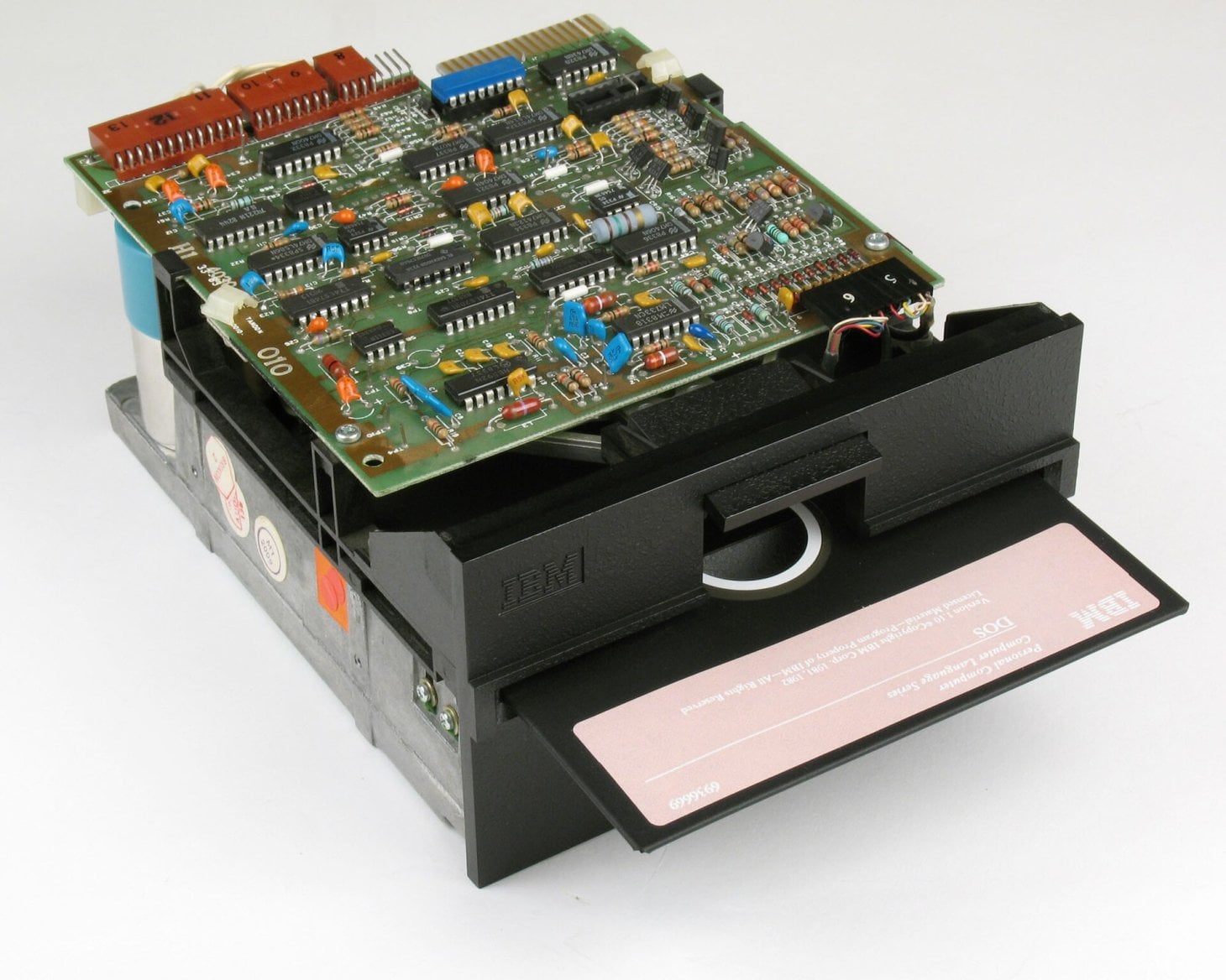 Odkrytá 5,25palcová mechanika IBM s viditelnou elektronikou a vloženou disketou DOS 1.1.