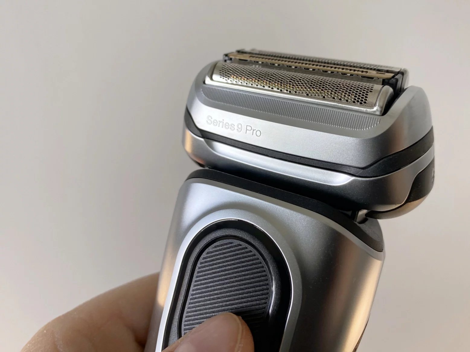 Na Braun Series 9 Pro+ najdete jen tlačítko na spuštění, přepínač pro aretování hlavice a na druhé straně vysunovací vestavěný zastřihovač ProTrimmer.