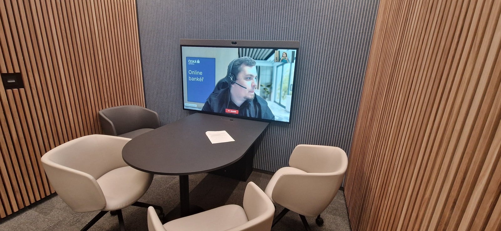 Místnost s obrazovkou pro online schůzky s bankéřem.