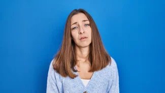 Žena s dlouhými vlasy s utrápeným výrazem
