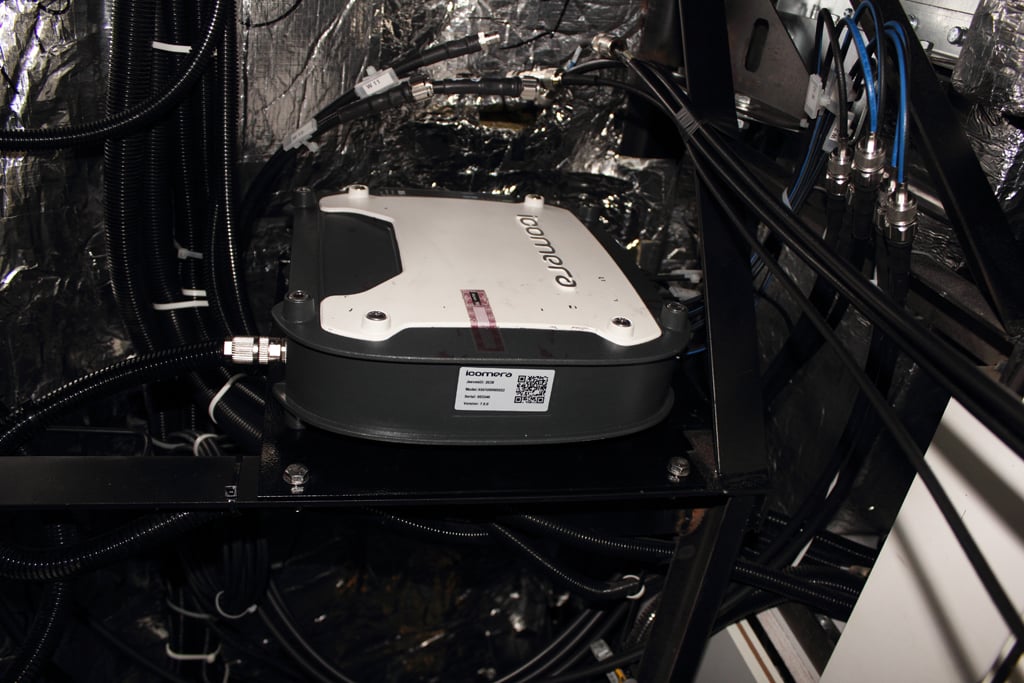 Pohled do prostoru mezi stropem a střechou vagónu. Ta bílá krabice je systém firmy Icomera, který obstarává připojení palubní wi-fi k mobilním sítím. České dráhy mají takových routerů momentálně něco kolem dvou set. Jsou v nich zapojeny SIM karty dvou operátorů (O2 a T-Mobile), karty všech tří tuzemských operátorů jsou jen v Pendolinech. Jedna SIM karta přenese asi 200 - 300 GB dat za měsíc. Při měření jsou k anténám na střeše vagónu místo routeru připojeny tři kabely vedoucí do mobilního skenneru ČTÚ.