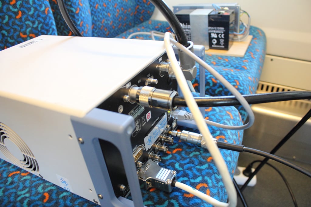 Skenner mobilních sítí. "Má dva anténní vstupy. Každá anténa může běžet separátně. Samozřejmě je tu vstup pro napájení, dále přívod signálu z GPS a LAN kabel do notebooku, kterým se sypou data do aplikace," popisuje Holek.  GPS údaje bere skenner z antény na střeše vagónu.