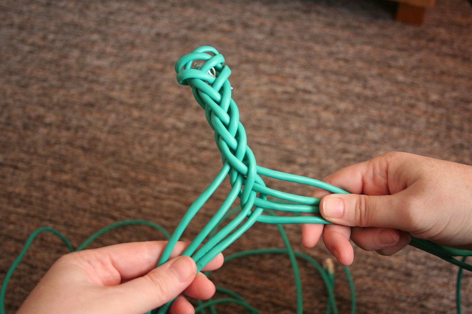 Rozdělíme osm kabelů na dvě půlky po čtyřech. Z levé strany dáme nejkrajnější prut předem na pravou stranu doprostřed mezi čtyři pravé pruty. Poté pokračujeme a protáhneme ho zadem a vrátíme na levou stranu úplně dolů. Poté opakujeme proces z pravé strany, opět s nejvrchnějším prutem.