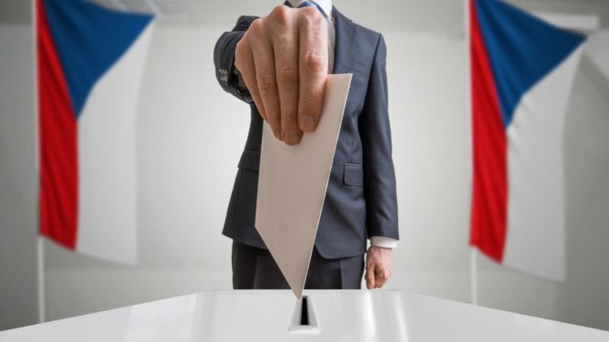 Podnikatel vhazuje do urny hlasovací lístek při volbách