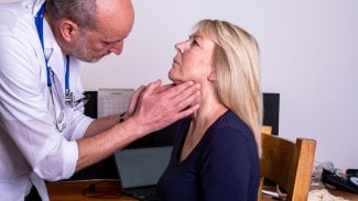 Lékař sahá starší pacientce na krk