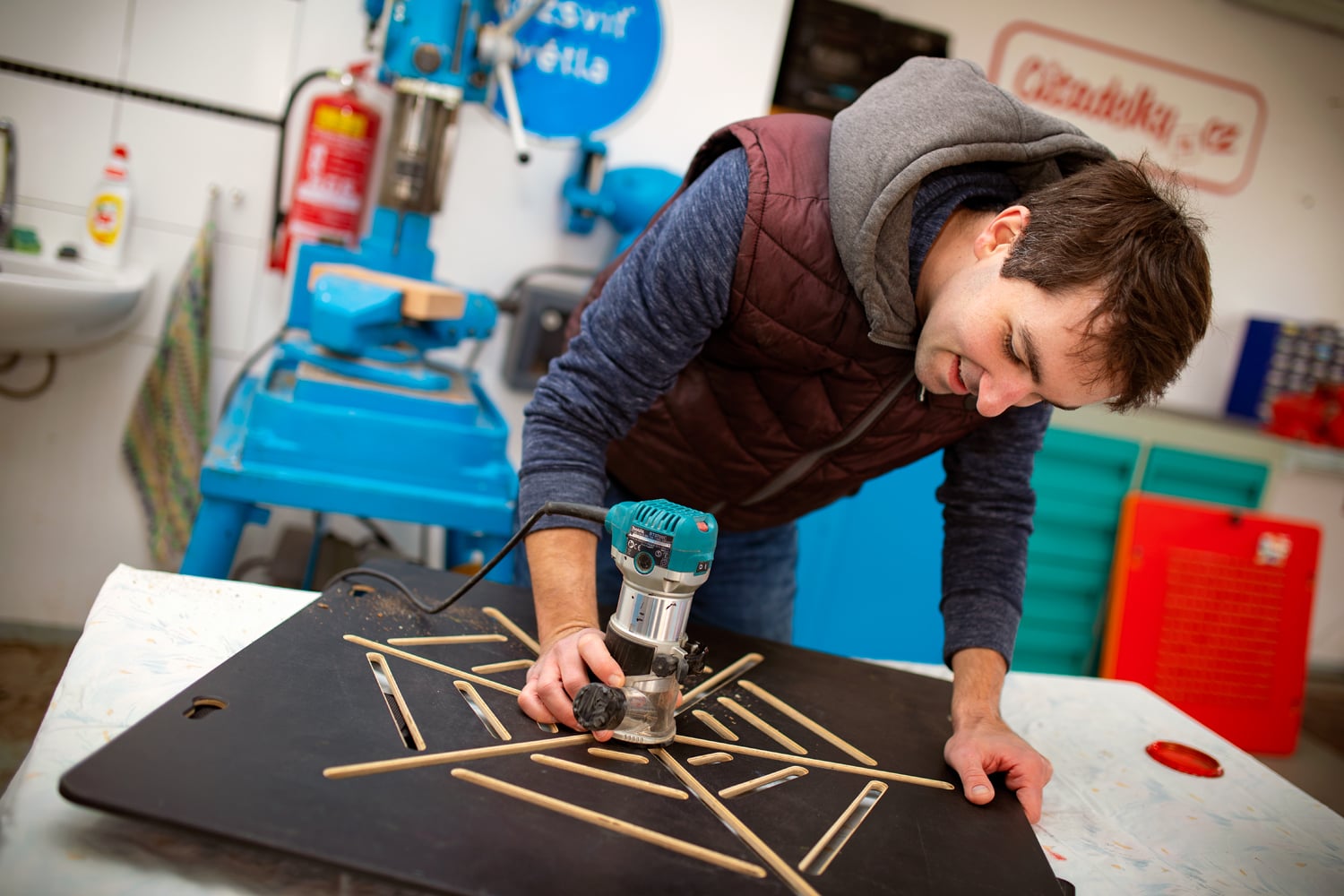 Ruční dobrušování překližkového dílu.