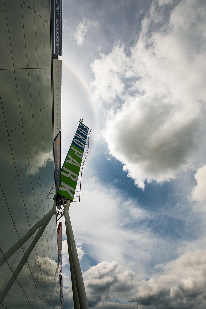 Antény jsou sice umístěny nad reklamním panelem, ale na první pohled celkem nenápadně a tvoří jeden celek poutače pražského obchodního centra. Nevzhledná kabelová trasa je vedena vnitřkem konstrukce.