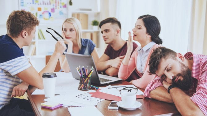 Mladí zaměstnanci znudění a unavení v práci při poradě