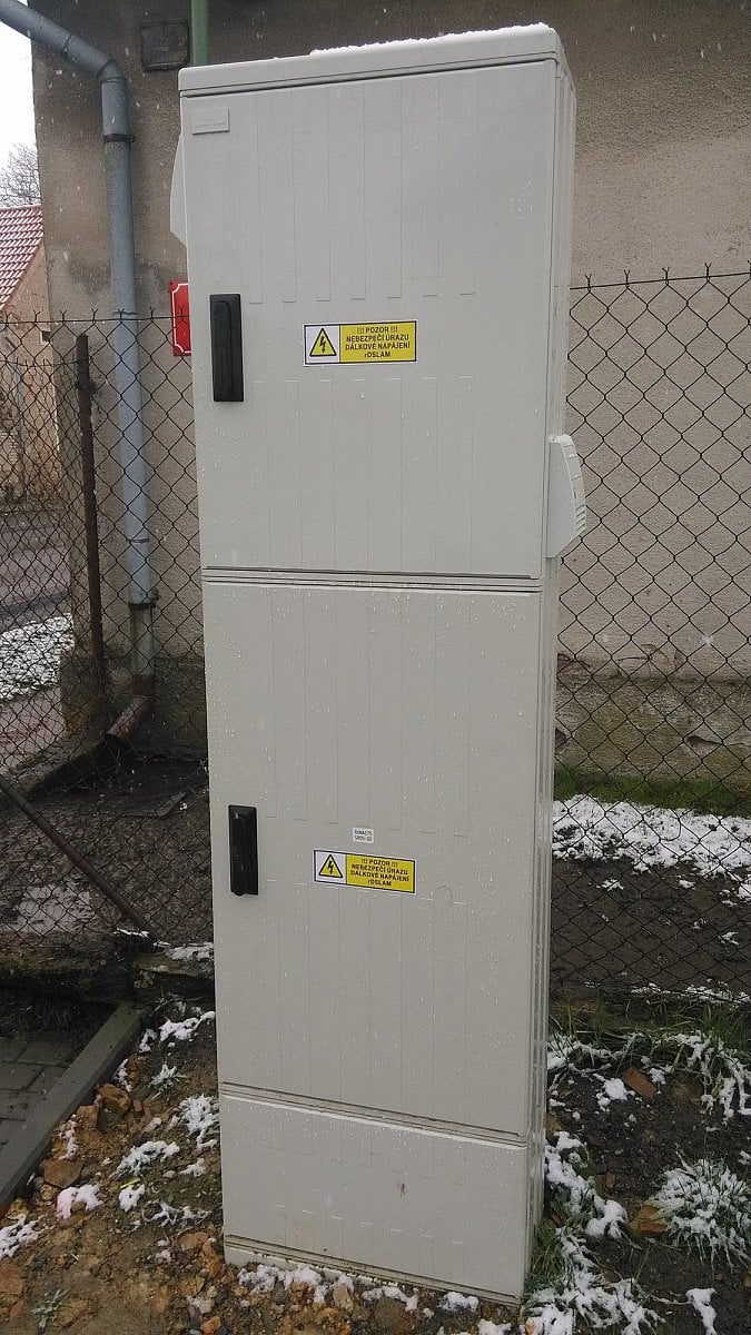 Celkový pohled na uzel FTTC (horní box) dodatečně posazený na existující síťový rozvaděč (dolní box).