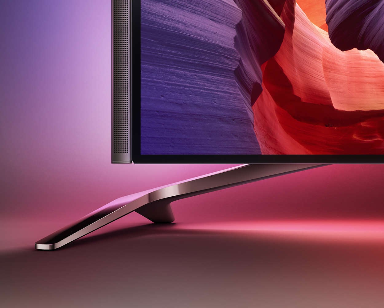 Nožičky přesahují přes šířku obrazovky, povšimněte si také zvukové lišty, která je k obrazovce připevněna magnetem.