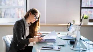 Mladá účetní zkoumá firemní faktury