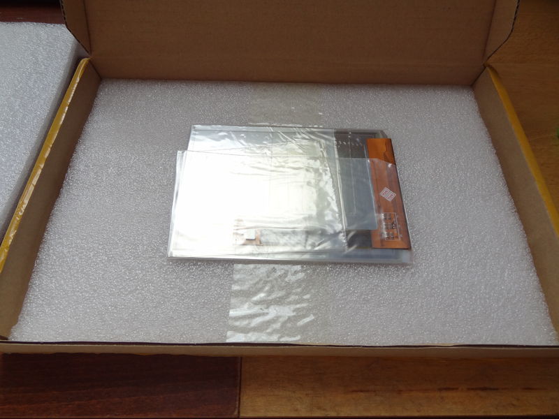 Otevřená krabice. Docela mě překvapilo, jakou si dali práci s tím, aby vše bylo přidělané. Displej je zabalen ve folii a přelepen páskou, dále přilepen znova k balicí pěně a následně přikryt druhým dílem pěny. Vše je udělané tak, že se po zavření krabice nemůže citlivý displej ani hnout.