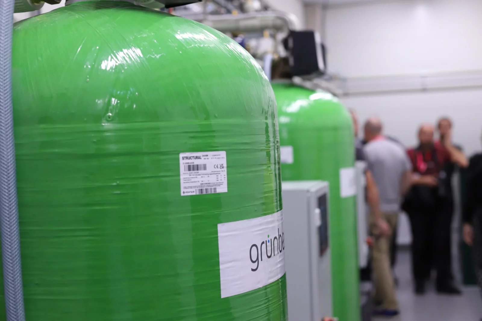 Úpravna dešťové vody. Velké zelené „lahve“ obsahují pískové filtry.