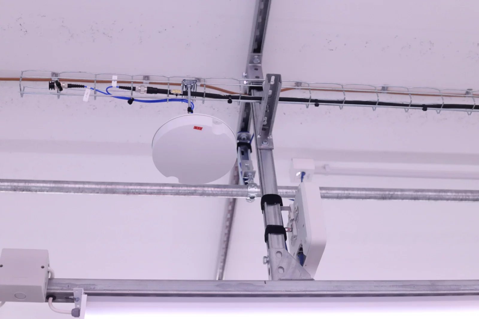 T-Mobile v DC7 testuje možnosti privátních 5G sítí v průmyslovém prostředí. O pokrytí sálů signálem se starají rádiové jednotky firmy Ericsson rozmístěné klasicky na stropech. Síť je připojena optikou k 5G SA core v interním datacentru na Roztylech, v DC7 je pak nainstalovaný local breakout server, který zajišťuje aplikacím velmi nízkou latenci.