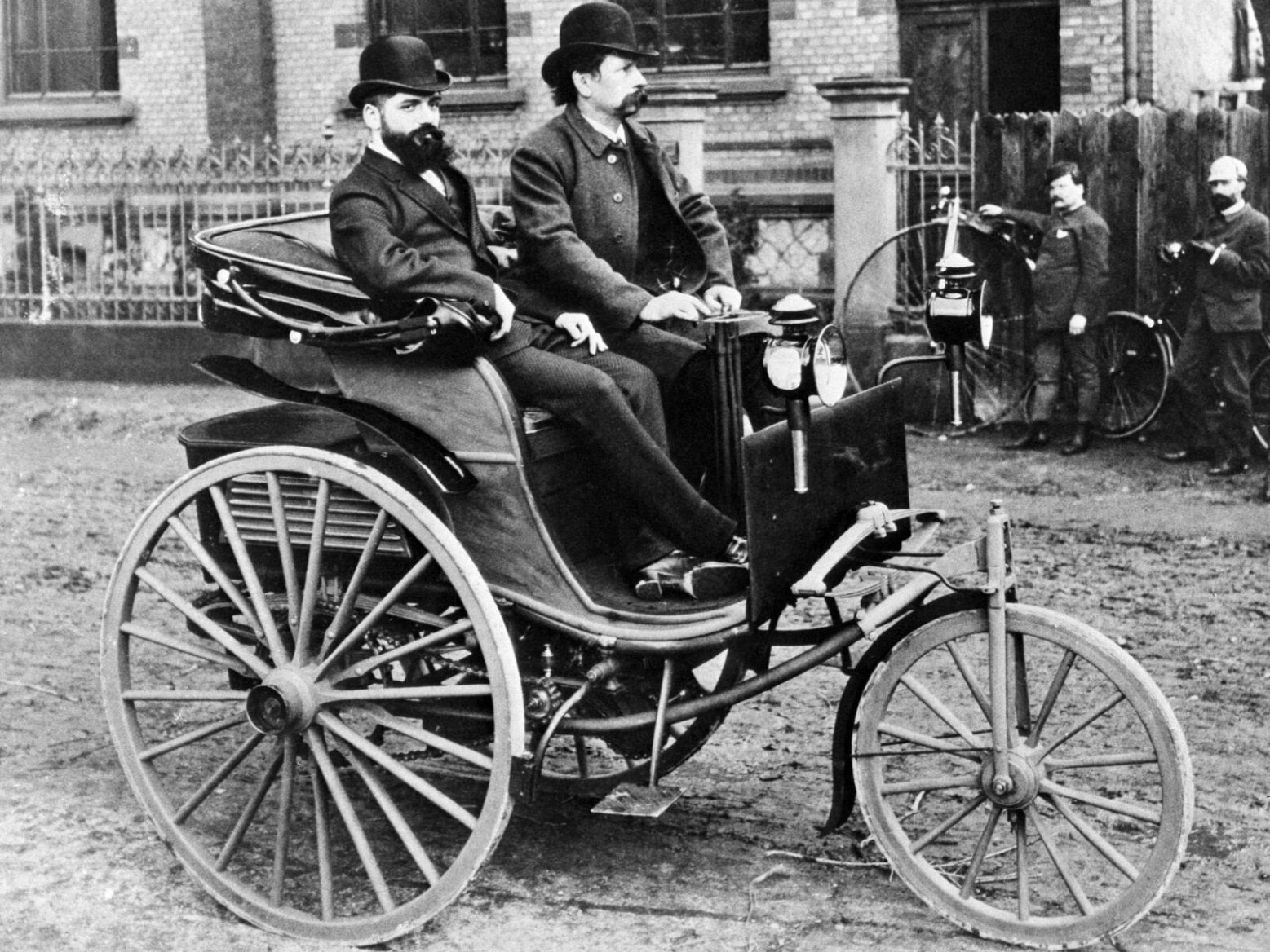 Carl Benz za řídící klikou tříkolky, ovšem jedná se patrně o třetí exemplář už s dřevěnými koly a dalšími odlišnostmi