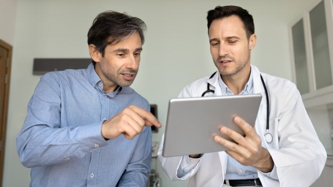 Muž středního věku hovoří s mladým lékařem