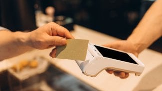 Ruka s kartou, která platí přes platební terminál