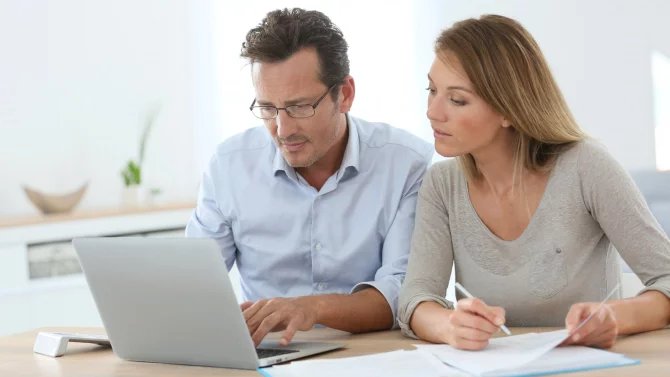 U počítače sedí muž a žena a tváří se zamyšleně.