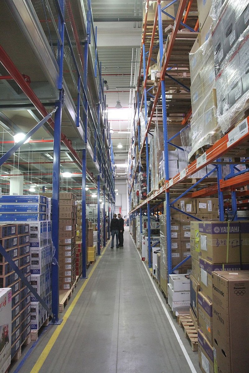Hala má 10 metrů na výšku. Podlahová plocha 10 tisíc metrů čtverečních. Aktuální skladová zásoba 36 tisíc položek. Většinu z toho tvoří černá technika. Ve skladu je zboží za zhruba 1,3 miliardy Kč.