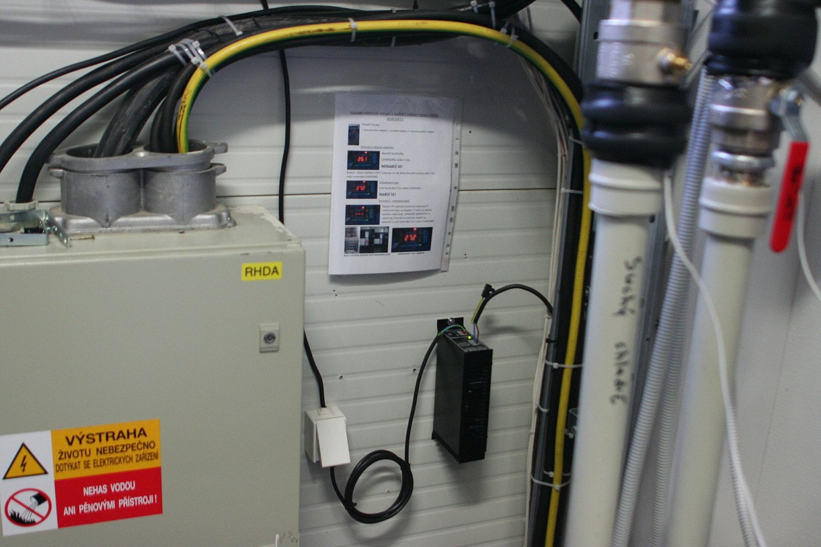Nabíječka startovací baterie v diesel agregátu. Je přímo za tou zdí.