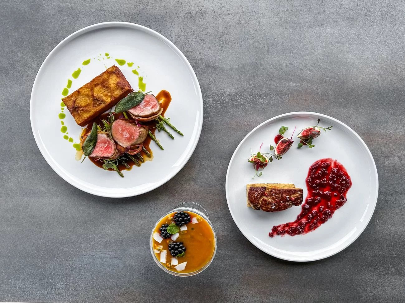 Druhé menu hořovické restaurace Na Krétě, hlavní chod grilovaná panenka zabalená v pancettě, šalvěj, omáčka z choriza, restovaný zelený baby chřest, bramborové pavé, předkrm restované foie gras, opečená máslová brioška, domácí brusinková omáčka se zázvorem a pomerančem