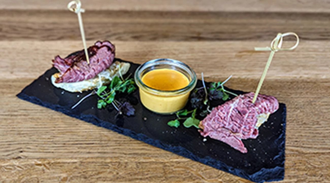 Domácí hovězí pastrami s kysaným zelím, omáčkou ze sýru raclette, medovou hořčicí a máslovou bulkou, Brloh Barbecue Mělník