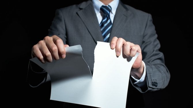 Muž v obleku trhá papír (končící formulář)