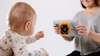 Malému dítěti měří zdravotnice zrak speciálním přístrojem
