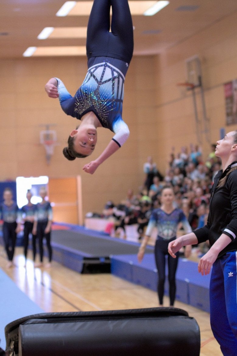 Obecně vypadají fotografie cvičenek při přeskoku focené na výšku o trošku lépe. A ptáte se po emocích? Všimněte si cvičenky, která kontroluje výšku a směr přeskoku, soustředěnou trenérku poskytující záchranu a nervozitu kolegyně cvičenky z týmu, případně i dalších třech v pozadí.
(Pentax K-S2, 1/500s f/2,8 ISO1250)
