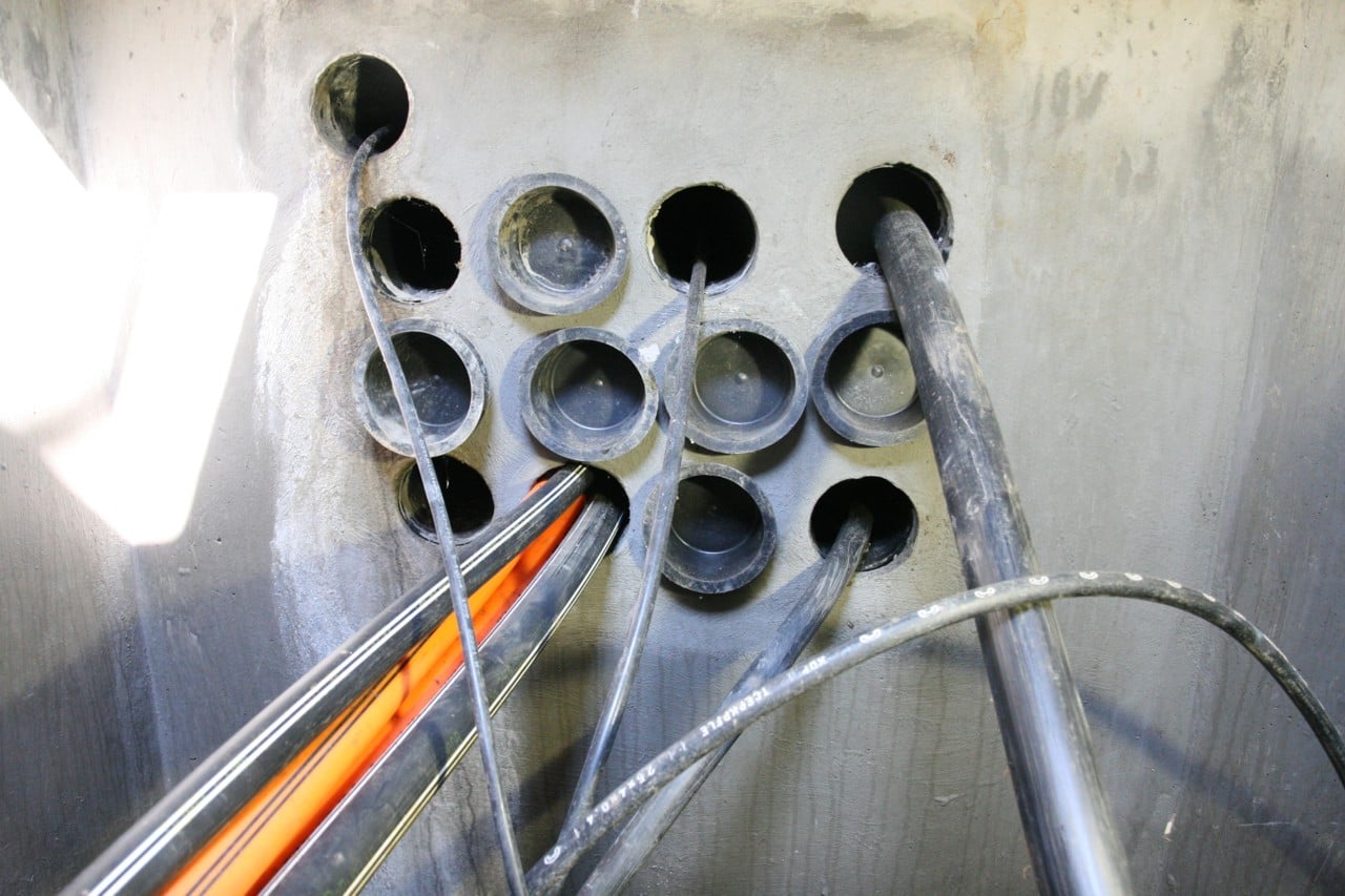 Vyústění kabelovodu v kabelové komoře.